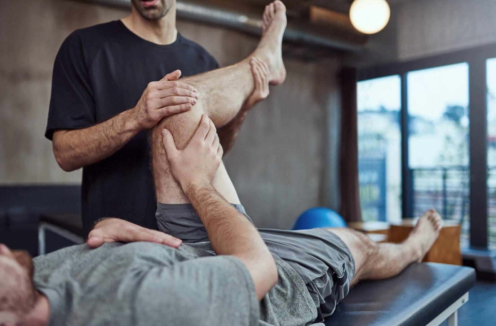 Shot of a young man visiting his physiotherapist for a rehabilitation session